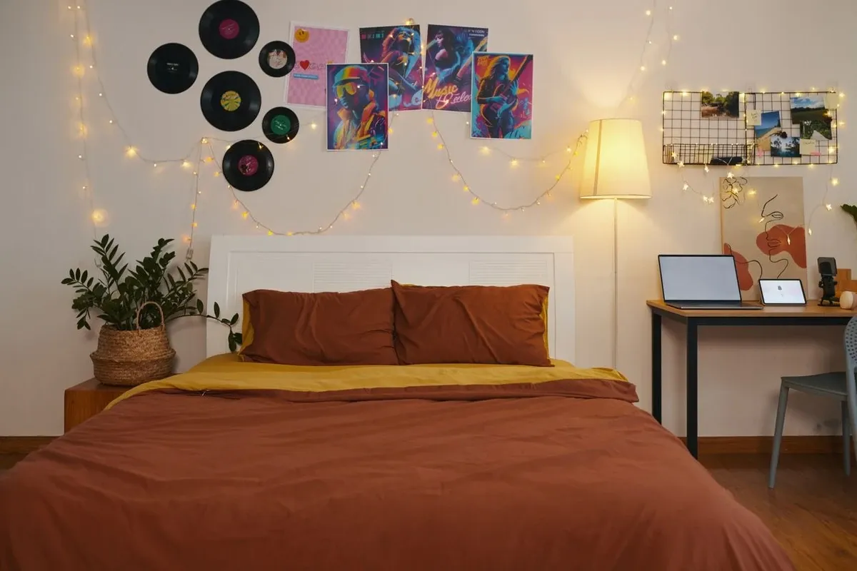 Image of bedroom with vinyl records and posters above the headboard.